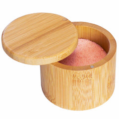 A partially open Salt Cellar with a swivel lid from Totally Bamboo reveals pink Himalayan salt inside. This elegant, 6-oz. capacity container showcases a smooth, natural wood finish, making it perfect for seasoning storage.