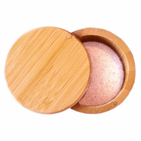 The Totally Bamboo Salt Cellar with Swivel Lid features a charming round bamboo design with a smooth wooden texture. Its partially open lid reveals an interior filled with pink Himalayan salt, making it perfect for seasoning storage due to its simple and natural design. It has a 6-ounce capacity.