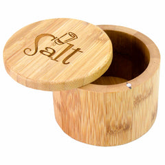 The "Salt Shaker" Engraved Salt Cellar by Totally Bamboo, with a 6-oz. capacity, is designed in a round bamboo shape and features a swiveling lid that is slightly open. The lid, engraved with "Salt" alongside a small shaker illustration, includes a magnetic lock to ensure secure closing. The visible wood grain contributes to its natural and rustic appeal.