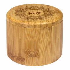 Introducing the "Mandala Salt" Engraved Salt Cellar by Totally Bamboo. This round, wooden salt cellar boasts a beautifully carved lid with a detailed floral mandala pattern and the word "Salt" at its center. Crafted from smooth, natural bamboo, it features a discreet magnetic lock to ensure your salt stays securely inside.