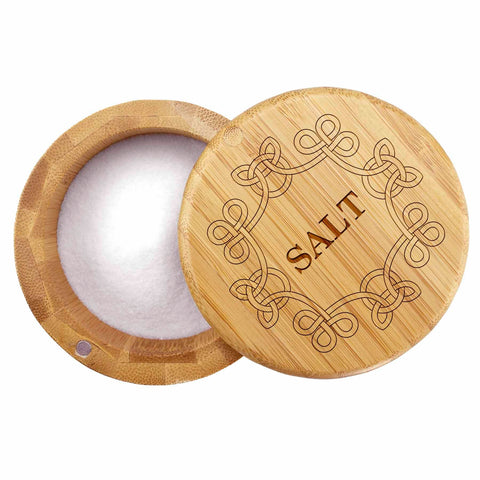 A "Celtic Knot" Engraved Salt Cellar by Totally Bamboo showcases its elegant design with the word "SALT" stylishly engraved on the lid. The lid, featuring a Celtic knot border design, is slightly open to reveal white salt inside and includes a magnetic lock to ensure secure closure.