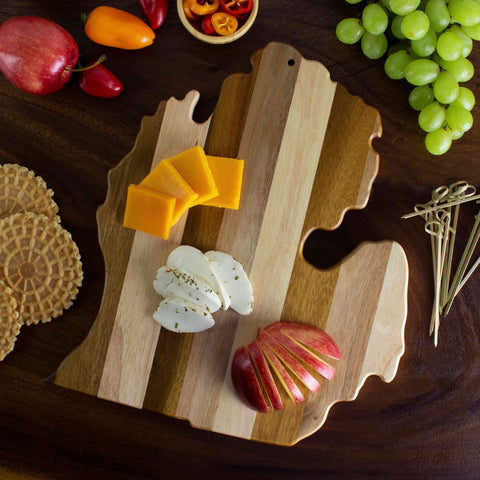 The Rock & Branch® Shiplap Series Michigan Mitten Cutting Board by Totally Bamboo, elegantly shaped like the state of Michigan, is adorned with cheese slices, crackers, and apple wedges. Surrounded by grapes and whole fruits with decorative picks, it transforms into a colorful and inviting snack display reminiscent of elegant wall art.