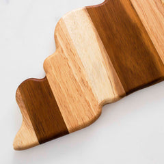 The Rock & Branch® Shiplap Series Kentucky Cutting Board by Totally Bamboo, designed with wavy edges and alternating light and dark wood grain stripes, reminiscent of decorative wall art, rests elegantly on a white surface.