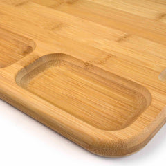 Close-up of the 3-Well Kitchen Prep Board by Totally Bamboo, showcasing its smooth bamboo finish. This 17-1/2" x 13-1/2" charcuterie board features rounded edges and an indented juice groove on one side, offering both style and functionality.