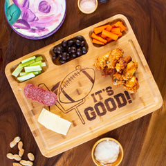 The "It's Good" 3-Well Kitchen Prep Board by Totally Bamboo, measuring 17-1/2" x 13-1/2", is the perfect canvas for showcasing an array of chicken wings, celery sticks, carrot sticks, black olives, sliced salami, cheese, and a small bowl of peanuts. Ideal for touchdown-dance snacks, this versatile board pairs beautifully with a purple and white plate and a side bowl of dip.