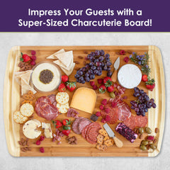 The Totally Bamboo 600SI Large Cutting Board & Noodle Board, measuring 30" x 20", showcases an artful assortment of various cheeses, cured meats, grapes, strawberries, nuts, crackers, and olives. Complete with a serving tool and a jar of dip, it's the perfect way to impress your guests effortlessly!