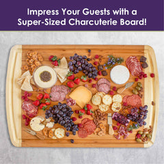 A generous charcuterie board showcasing assorted meats, cheeses, grapes, crackers, and spreads adorns a rustic wooden surface. Text on top reads, "Impress Your Guests with the Totally Bamboo 800SI XL Cutting Board & Noodle Board!" Perfect for any gathering.