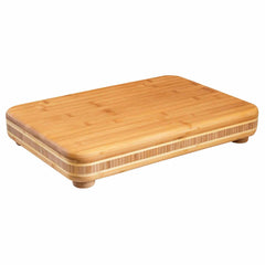 The "Big Easy" Chopping Block by Totally Bamboo, measuring 19" x 13-1/2", features elevated legs and a smooth surface with a light wood grain pattern—ideal for food preparation.