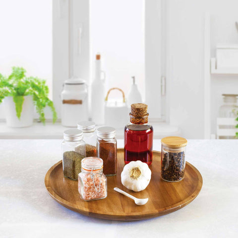 Photo of the Acacia Wood Lazy Susan with bottles of spices in a kitchen setting