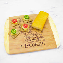 From the Slice of Life Collection by Totally Bamboo, the "A Slice of Life Wisconsin Cutting Board" measures 11" x 8-3/4" and showcases laser-engraved artwork with a map of Wisconsin and the word "Wisconsin." It is adorned with cheese, crackers topped with cheese, a slice of tomato, and green pepper for added color.