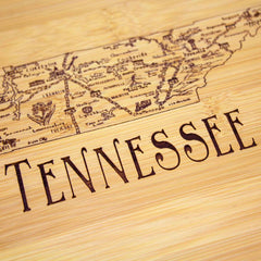 Introducing the Totally Bamboo "A Slice of Life Tennessee Cutting Board," measuring 11" x 8-3/4". This bamboo cutting board showcases a laser-engraved outline map of Tennessee, adorned with cities and landmarks, and prominently features the word "TENNESSEE" in large letters. It's the perfect charcuterie board for proud locals or fans of the Volunteer State.