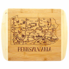 The Totally Bamboo "A Slice of Life Pennsylvania Cutting Board" is a beautifully crafted bamboo piece, laser-engraved with a detailed map of Pennsylvania. It highlights cities and landmarks such as Pittsburgh, Harrisburg, and Philadelphia, and proudly displays "PENNSYLVANIA" at the bottom. This 11" x 8-3/4" cutting board serves as an ideal choice for charcuterie presentation or as eye-catching kitchen décor.