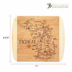 The "A Slice of Life Michigan Cutting Board" by Totally Bamboo is ideal for charcuterie serving, featuring an intricately engraved map of Michigan with major cities and landmarks. Measuring 11 by 8-3/4 inches, it includes the Totally Bamboo logo in the top right corner, adding a charming state outline to your kitchen.