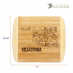 A Slice of Life Oklahoma Cutting Board by Totally Bamboo is a bamboo charcuterie serving board featuring an engraved map of Oklahoma with city names and landmarks. It measures 11 inches by 8-3/4 inches and showcases state outline artwork. The Totally Bamboo logo is proudly displayed in the top right corner.