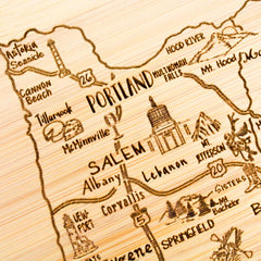 Discover Totally Bamboo's A Slice of Life Oregon Cutting Board, a unique wooden map engraving that showcases cities like Portland, Salem, and Eugene. This 11" x 8-3/4" state outline artwork features charming illustrations of Mt. Hood, Multnomah Falls, and coastal treasures such as Astoria and Cannon Beach—perfect for adding character to any space.