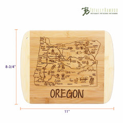 As a piece from the Slice of Life Collection, the A Slice of Life Oregon Cutting Board by Totally Bamboo presents an engraved map of Oregon's state outline, highlighting landmarks and cities. It measures 11 inches by 8-3/4 inches and prominently displays the "Totally Bamboo" brand above the map.