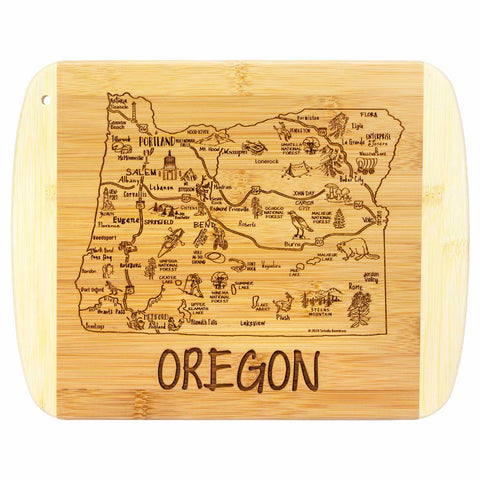 As a part of Totally Bamboo's Slice of Life Collection, the A Slice of Life Oregon Cutting Board (11" x 8-3/4") showcases a beautifully engraved map of Oregon, complete with illustrations of trees, mountains, and wildlife. The word "OREGON" is prominently featured at the bottom in elegant state outline artwork.