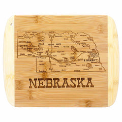 From the Slice of Life Collection by Totally Bamboo, this 11" x 8-3/4" Nebraska cutting board features an engraved detailed map showcasing cities, roads, and landmarks such as the Sand Hills and Chimney Rock. The word "Nebraska" is artfully carved at the bottom.