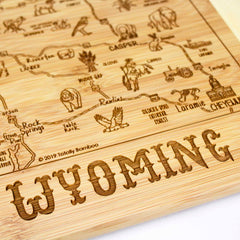 Explore the allure of our A Slice of Life Wyoming Cutting Board by Totally Bamboo, measuring 11" x 8-3/4". This beautifully crafted wooden map of Wyoming showcases laser-engraved landmarks, cities, and natural features to perfectly capture the essence of the state. The word "WYOMING" is prominently engraved at the bottom for a distinctive finishing touch.