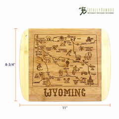 Explore the A Slice of Life Wyoming Cutting Board by Totally Bamboo, featuring a laser-engraved map of Wyoming with highlights such as Casper, Cheyenne, landmarks, and wildlife. This bamboo board measures 11 inches by 8-3/4 inches, with the Totally Bamboo logo elegantly placed in the top right corner.