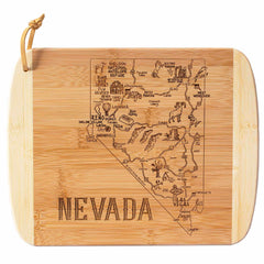 This Totally Bamboo "A Slice of Life Nevada Cutting Board" features an engraved map of Nevada, highlighting major cities such as Las Vegas and Reno, along with notable landmarks, wildlife, and natural features. The word "NEVADA" is carved at the bottom, and a leather loop is included for convenient hanging. Measuring 11 inches by 8-3/4 inches, this bamboo cutting board is a part of the Slice of Life Collection.