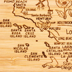 The 4-Piece California Puzzle Coaster Set with Case by Totally Bamboo offers a uniquely carved wooden map of California, showcasing areas such as Santa Barbara and Malibu. It includes laser-engraved details like the islands of San Miguel and Santa Cruz, and even features a sea lion near San Clemente Island, making it an exceptional addition to any State Puzzle Coaster Set.