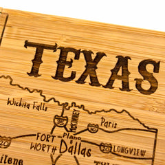 A laser-engraved artwork from the Totally Bamboo 4-Piece Texas Puzzle Coaster Set with Case highlights Wichita Falls, Plano, Fort Worth, Dallas, and Longview. The detailed carving features major highways with "TEXAS" etched at the top—an ideal gift.