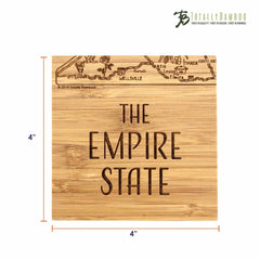 A unique square coaster from the 4-Piece New York Puzzle Coaster Set with Case by Totally Bamboo showcases laser-engraved artwork titled "THE EMPIRE STATE" alongside a partial map illustration. Measuring 4x4 inches, it features the Totally Bamboo logo in the top right corner.