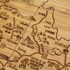 Discover the Totally Bamboo 4-Piece Idaho Puzzle Coaster Set with a vintage-style laser-engraved map on wooden coasters. It features locations like Salmon, Challis, and Sun Valley as well as geographical wonders such as the Lost River Range and landmarks like Craters of the Moon National Monument.