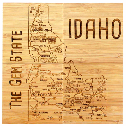 The 4-Piece Idaho Puzzle Coaster Set with Case, by Totally Bamboo, features a wooden map of Idaho labeled "The Gem State," showcasing city names, mountain ranges, and various landmarks. Expertly crafted like a laser-engraved coaster, it prominently displays "IDAHO" on the right side.