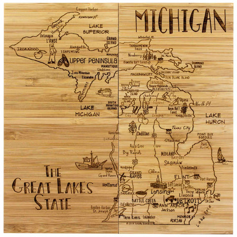 A detailed map of Michigan is laser-engraved on a wooden board, showcasing major cities, lakes, the Upper Peninsula, and notable landmarks. The phrase "The Great Lakes State" is elegantly displayed in the bottom left corner, making it a distinctive coaster gift from the 4-Piece Michigan Puzzle Coaster Set with Case by Totally Bamboo.