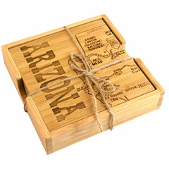 The 4-Piece Arizona Puzzle Coaster Set with Case by Totally Bamboo features wooden coasters laser-engraved with "Arizona" and unique illustrations of landmarks, including the Grand Canyon. Tied together with rustic twine, these coasters offer a charming way to celebrate your travels.