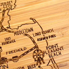 Discover the 4-Piece New Jersey Puzzle Coaster Set with Case by Totally Bamboo, featuring a wooden engraving that highlights towns such as Middletown, Long Branch, Asbury Park, East Brunswick, Freehold, and Point Pleasant Beach. This unique gift includes an iconic Ferris wheel symbol near Point Pleasant Beach.