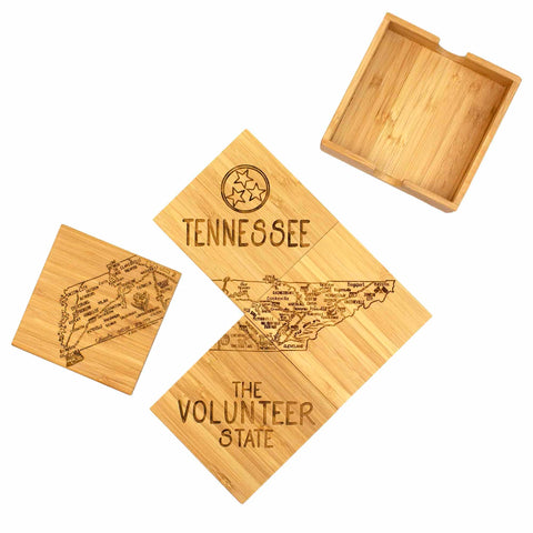 The 4-Piece Tennessee Puzzle Coaster Set with Case by Totally Bamboo features wooden coasters adorned with laser-engraved artwork, showcasing a map of Tennessee along with the text "TENNESSEE," "THE VOLUNTEER STATE," and the state symbol. Organized in a diamond shape and complemented by an open wooden box, these coasters are ideal gifts for any occasion.