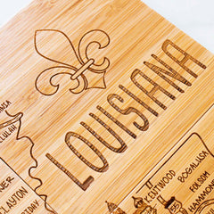 The 4-Piece Louisiana Puzzle Coaster Set with Case by Totally Bamboo creatively features laser-engraved artwork that highlights "Louisiana" alongside a fleur-de-lis, and includes a detailed map showing city names such as Kentwood, Bogalusa, and Hammond. This distinctive set mirrors the style of a State Puzzle Coaster with road numbers and decorative touches.