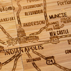 The 4-Piece Indiana Puzzle Coaster Set with Case by Totally Bamboo features a detailed laser-engraved design that highlights key cities in Indiana such as Indianapolis, Kokomo, and Muncie. Major highways like I-70 and I-74 are clearly depicted, alongside an illustration of the Indiana State Capitol in Indianapolis. This sophisticated piece is an ideal gift for any geography enthusiast.