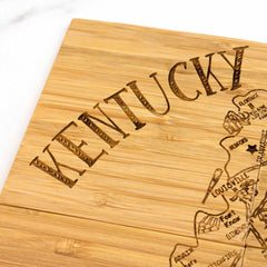 This exquisite 4-piece Kentucky Puzzle Coaster Set with Case by Totally Bamboo features a bamboo composition, with "Kentucky" beautifully engraved. Each coaster artistically showcases a partial map depicting various cities and towns, capturing the essence of Louisville and Fort Knox in remarkable detail.