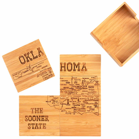 This 4-Piece Oklahoma Puzzle Coaster Set with Case by Totally Bamboo features laser-engraved coasters highlighting major cities on a map of Oklahoma. It includes three distinct coasters labeled "OKLA," "THE SOONER STATE," and the largest piece showcasing the map, all accompanied by an empty wooden box for storage.