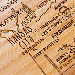 The 4-Piece Missouri Puzzle Coaster Set with Case by Totally Bamboo showcases intricately engraved city names and landmarks, highlighting places like Kansas City, Plattsburg, and Warrensburg. Featuring laser-engraved depictions of buildings and roads, this wooden map also functions as a distinctive coaster for your coffee table.