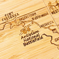 Close-up view of engraved Maryland map artwork on bamboo coaster