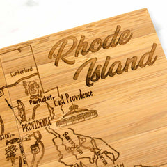 The 4-Piece Rhode Island Puzzle Coaster Set with Case by Totally Bamboo intricately laser-engraves a map outline featuring cities and landmarks such as Providence and East Providence on each wooden coaster. The set also beautifully scripts "Rhode Island" at the top, serving not only as coasters but also as a unique wooden cutting board.