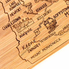 Discover a unique gift with this 4-Piece New Hampshire Puzzle Coaster Set with Case by Totally Bamboo. It features wooden engravings that highlight towns like Charlestown, Keene, and Peterborough, along with charming illustrations of local landmarks such as stores and mountains—perfect for those who appreciate intricate craftsmanship.