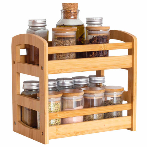 The Totally Bamboo 2-Tier Spice Caddy elegantly organizes assorted spice and herb jars topped with metal and cork lids. This neatly arranged setup not only optimizes kitchen storage but also serves as a chic bamboo storage solution.