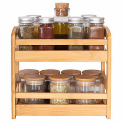 This aesthetically pleasing 2-Tier Spice Caddy by Totally Bamboo offers a chic solution for organizing spices and seasonings. It accommodates multiple glass jars with assorted contents. The top tier includes jars with metal lids alongside a small corked bottle, while the bottom tier highlights jars with wooden lids, making it an ideal addition for any spice enthusiast's collection.