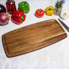 Angled photo of the 16 inch Acacia Wood cutting board with juice groove with vegetables