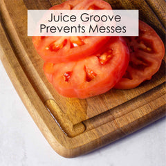 Photo close up of the 16 inch Acacia Wood cutting board with juice groove showing juice from a cut tomato draining into the groove, text reads juice groove prevents messes