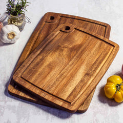 Angled photo of the 2-Piece Acacia Wood Cutting Board Set with vegetables