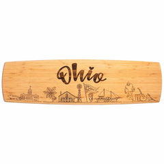 The Ohio Engraved XL Charcuterie Board by Totally Bamboo, measuring 30" x 8-1/2", showcases laser-engraved artwork with "Ohio" at its core. It features intricate drawings of a lighthouse, a flower, and a windmill, alongside iconic elements that celebrate Ohio's cultural heritage, making it an ideal centerpiece for your cheese plate.