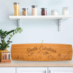 Photo of the South Carolina Extra-Large Charcuterie Board sitting upright on a kitchen counter leaning against the back splash