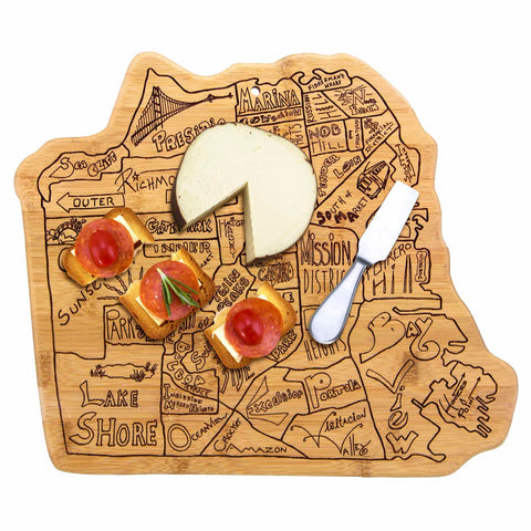 The Totally Bamboo City Life San Francisco Cutting Board, measuring 12-3/4" x 10-3/4", boasts a bamboo surface intricately shaped like a city map, featuring laser-engraved neighborhood names. A partially cut cheese wheel rests beside three pieces of topped toast and a cheese knife.